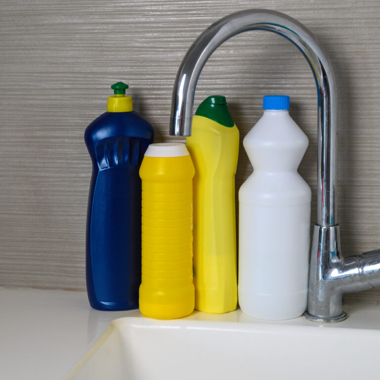 Detergent bottles at kitchen in home. Detergents and laundry concept.
