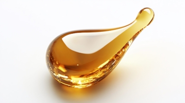 Golden liquid drop isolated on white.