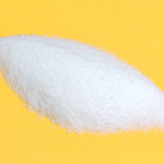 Close-up of pile of sugar isolated on a yellow background