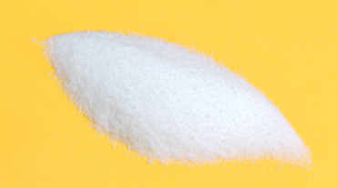 Close-up of pile of sugar isolated on a yellow background