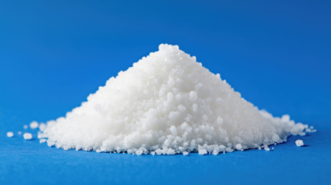 Pile of white powder on a blue surface. The powder is white and he is salt