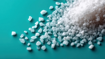 Pouring sea salt on turquoise surface food photography kitchen setting close-up culinary art